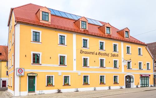 a large yellow building with a red roof at Brauereigasthof-Jakob in Nittenau