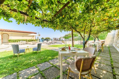 a table and chairs under a tree in a yard at Residenza Al Pesce D'Oro in Amalfi