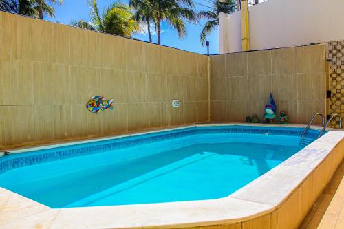 a swimming pool with a tiled wall at Pousada Farol do Porto Nova ADM 2026 in Porto De Galinhas