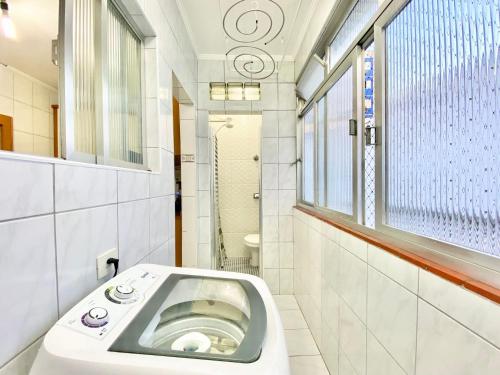 a bathroom with a toilet and a window at Canal 5 Embaré a 500 m da Praia in Santos