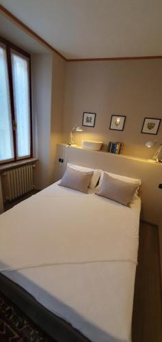uma grande cama branca num quarto com uma janela em APPARTAMENTO DI BAC em Mergozzo