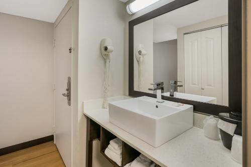 y baño con lavabo blanco y espejo. en Red Roof Inn PLUS+ & Suites Knoxville West - Cedar Bluff, en Knoxville