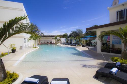 a swimming pool with lounge chairs next to a building at Hotel Tulija Palenque in Palenque