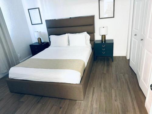 a bedroom with a large bed and two night stands at New Star Suite One in North Miami Beach