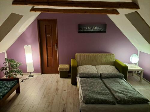 sypialnia z łóżkiem i fioletową ścianą w obiekcie Apartament Zielony Zakątek w mieście Sokołowsko