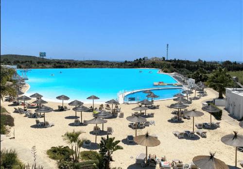 een groot zwembad van blauw water met stoelen en parasols bij EsteponaCies in Estepona