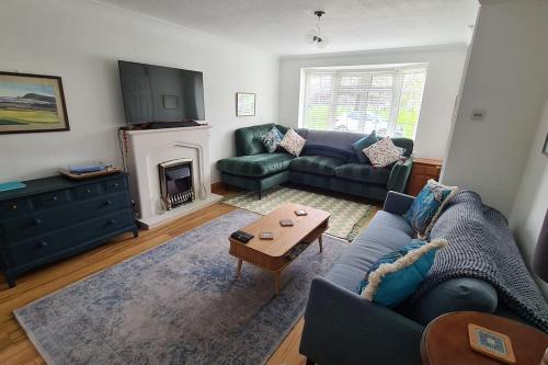 a living room with a blue couch and a fireplace at Haven Cottage - adjacent to beach and promenade in Walmer