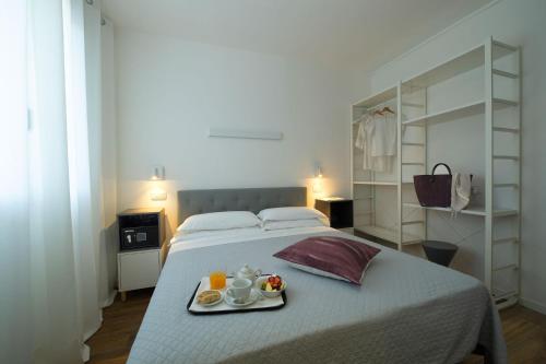 a bedroom with a bed with a tray of food on it at Nice Hotel Bibione in Bibione