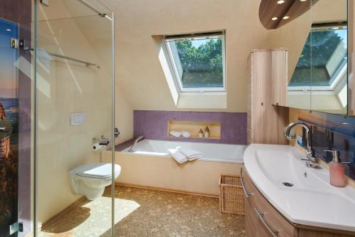 ein Badezimmer mit einer Badewanne, einem WC und einem Waschbecken in der Unterkunft Laasenhof Resort in Struppen
