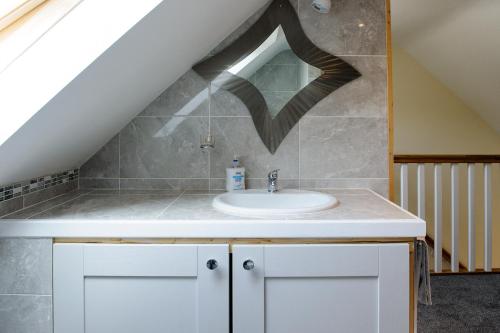 a bathroom with a sink in a attic at Honeysuckle Cottage in Renvyle