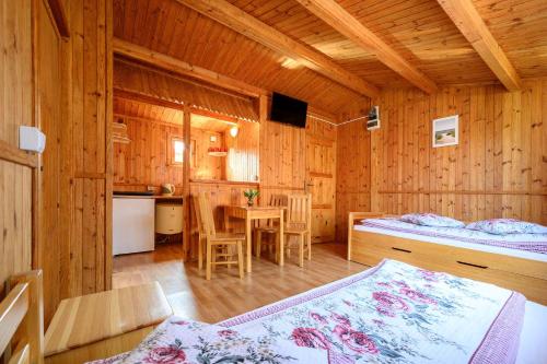 sypialnia z łóżkiem i stołem w pokoju w obiekcie Domki AGA nad morzem w mieście Bobolin