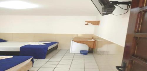 Habitación pequeña con 2 camas y lavamanos en Pousada Farol do Porto, en Porto de Galinhas