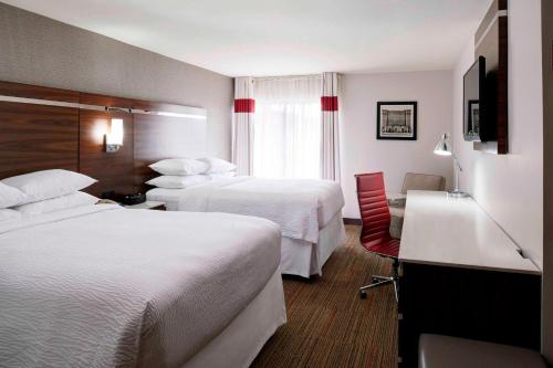 um quarto de hotel com duas camas e uma secretária em Four Points by Sheraton Detroit Novi em Novi