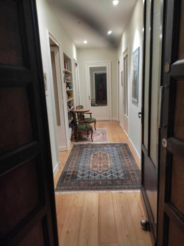 a hallway with a door and a rug at casa silvio pellico in Cuneo