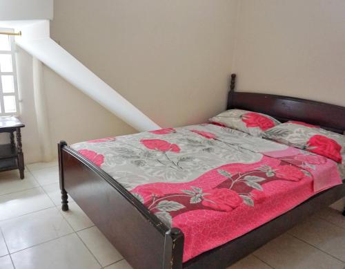 um quarto com uma cama com um cobertor vermelho e cinzento em Casa Ballena em Crucita