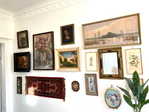 a wall full of framed pictures on a wall at CHATA OTWARTYCH OKIENNIC Pokoje Gościnne in Supraśl