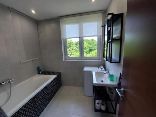 ein Badezimmer mit einer Badewanne und einem Waschbecken in der Unterkunft Útulný apartmán v Bratislava 4 in Bratislava