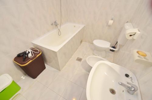 baño blanco con bañera, lavabo y aseo en Nikola - Two Bedroom Ap. with SeaView, en Kotor