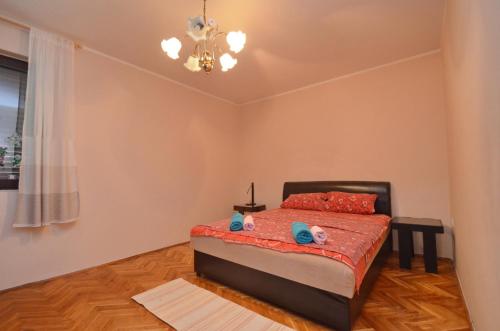 een slaapkamer met een bed en een kroonluchter bij Nikola - Two Bedroom Ap. with SeaView in Kotor