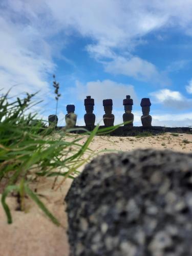 un grupo de estatuas sentadas en la cima de una playa en Moehiva Camping Rapa Nui, en Hanga Roa