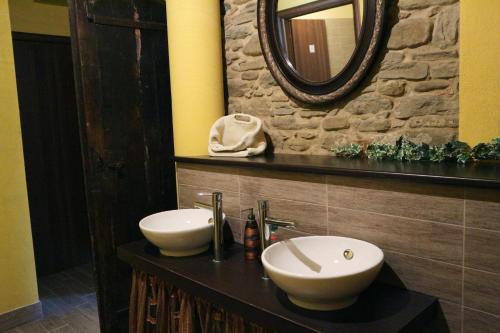 a bathroom with two sinks and a mirror at LA CASA IN CAMPAGNA esclusiva in Calosso
