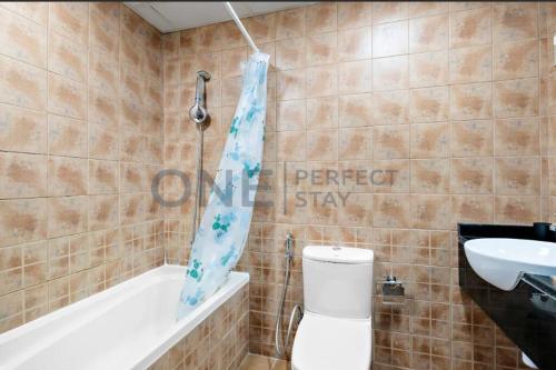a bathroom with a toilet and a tub and a sink at Lake View All Bills Included Fully furnished in Dubai