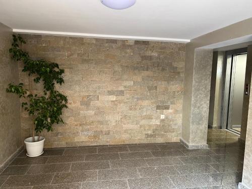 a room with a brick wall with a potted plant at Stamatovi Family Hotel in Pomorie