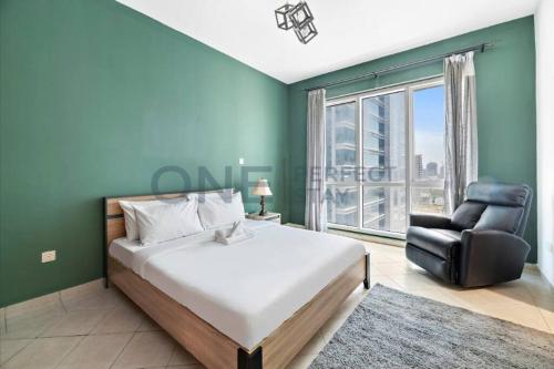 een slaapkamer met een bed, een stoel en een raam bij Lake View All Bills Included Fully furnished in Dubai