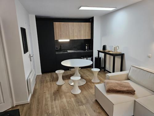 uma sala de estar com uma mesa branca e um sofá em T2 Saint Jean de Luz 200m plage em Saint-Jean-de-Luz
