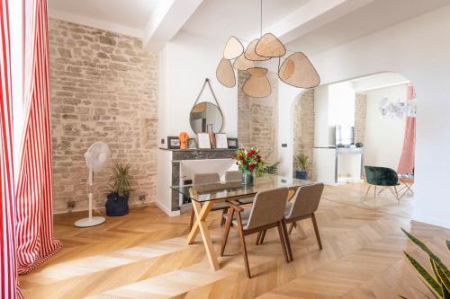 comedor con mesa y pared de ladrillo en Harmonie, en Nimes