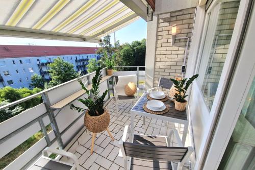 a patio with a table and chairs on a balcony at 3 Zi, Balkon, ruhig, 73m²: ein Hauch von Luxus in Ulm