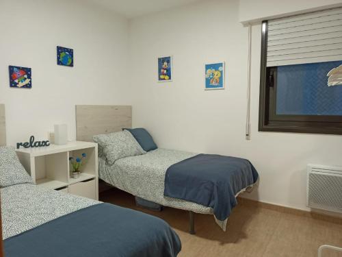 1 Schlafzimmer mit 2 Einzelbetten und einem Fenster in der Unterkunft Apartamento Bolboretas con parking privado in Ares
