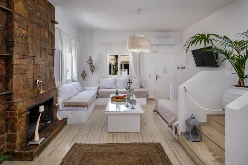 a living room with white furniture and a fireplace at Sol Mare Salis in Kamari