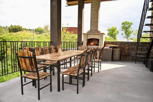 a wooden table and chairs with a fireplace on a patio at Guest House Climbing 