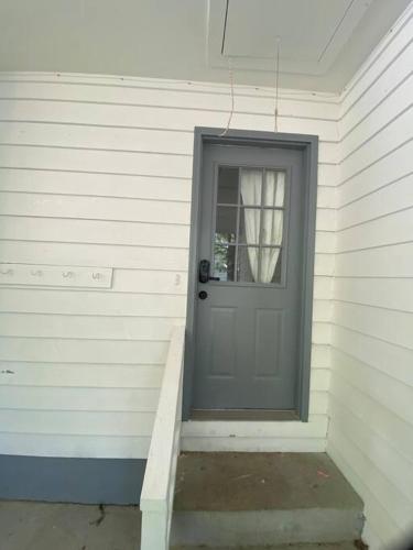 a gray door on a white house with a stairs at Your Own Lakehouse in Macon
