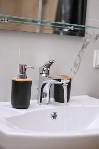 - un lavabo avec un robinet et une tasse dans l'établissement RiverHome Cottage, à Kʼaghsi