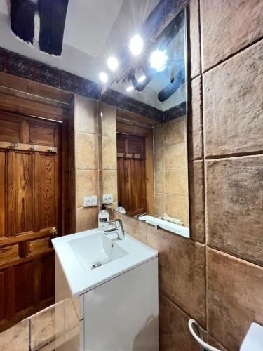 La salle de bains est pourvue d'un lavabo blanc et d'un miroir. dans l'établissement Ático Atocha Ile, à Madrid