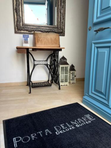 a blue door with a black rug in front of a door at PortaDelMare deluxe suites in Hydra