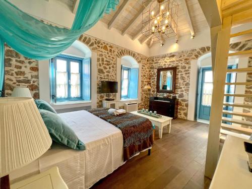 a bedroom with a bed in a room with stone walls at PortaDelMare deluxe suites in Hydra