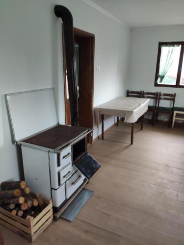 ein Raum mit einem Ofen und einem Tisch und einer Bank in der Unterkunft Kuca idealna za odmor i uzivanje u Vrdniku broj 4 in Vrdnik