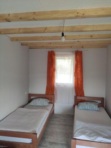 Duas camas num quarto com uma janela em Kuca idealna za odmor i uzivanje u Vrdniku broj 4 em Vrdnik
