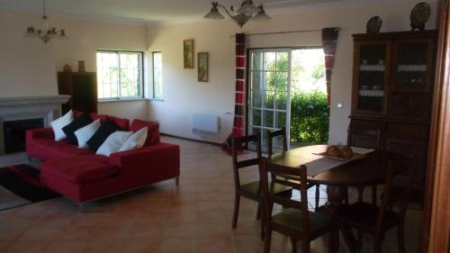 a living room with a red couch and a table at Casa "Pinho" com Jacúzi! in São Pedro do Sul
