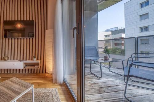 a balcony with a table and a glass door at COSY FLAT direct access Genève-Airport-Palexpo in Annemasse
