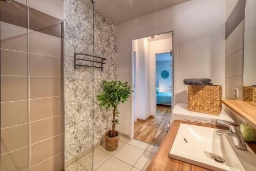 a bathroom with a sink and a glass shower at COSY FLAT direct access Genève-Airport-Palexpo in Annemasse