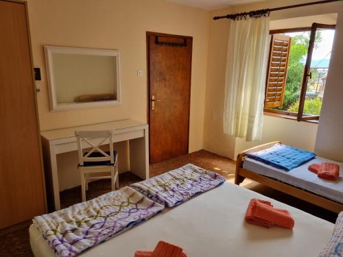 a room with two beds and a desk and a window at House Lopica in Senj
