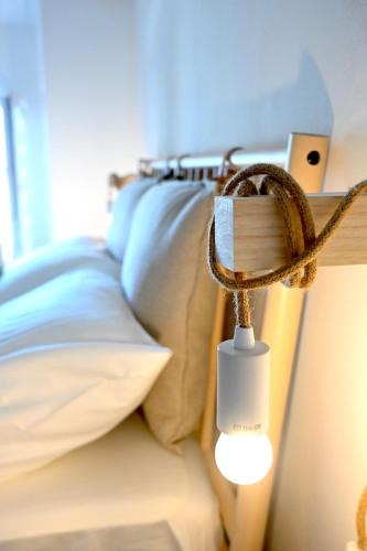 a light on the side of a bed with pillows at Sweet House Elisa in Treglio