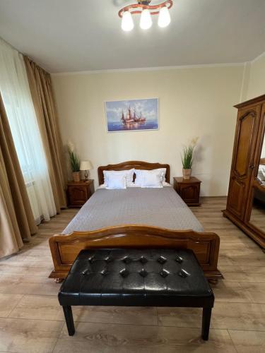 a bedroom with a large bed with a black bench at Valentino´s Residence in Constanţa