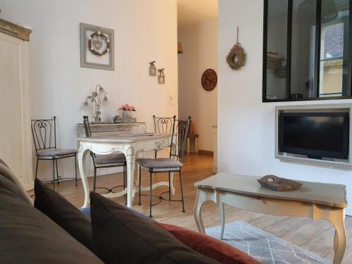 a living room with a table and a tv at L appart d en face in Sarlat-la-Canéda