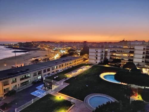 eine Stadt mit Gebäuden und einem Strand in der Nacht in der Unterkunft OceanFront & Big Terrace Private Condo in Oeiras