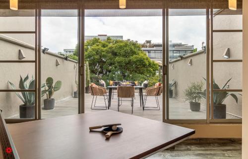 Habitación con ventanas grandes y mesa con tijeras. en Villa Polanco by Kukun, en Ciudad de México